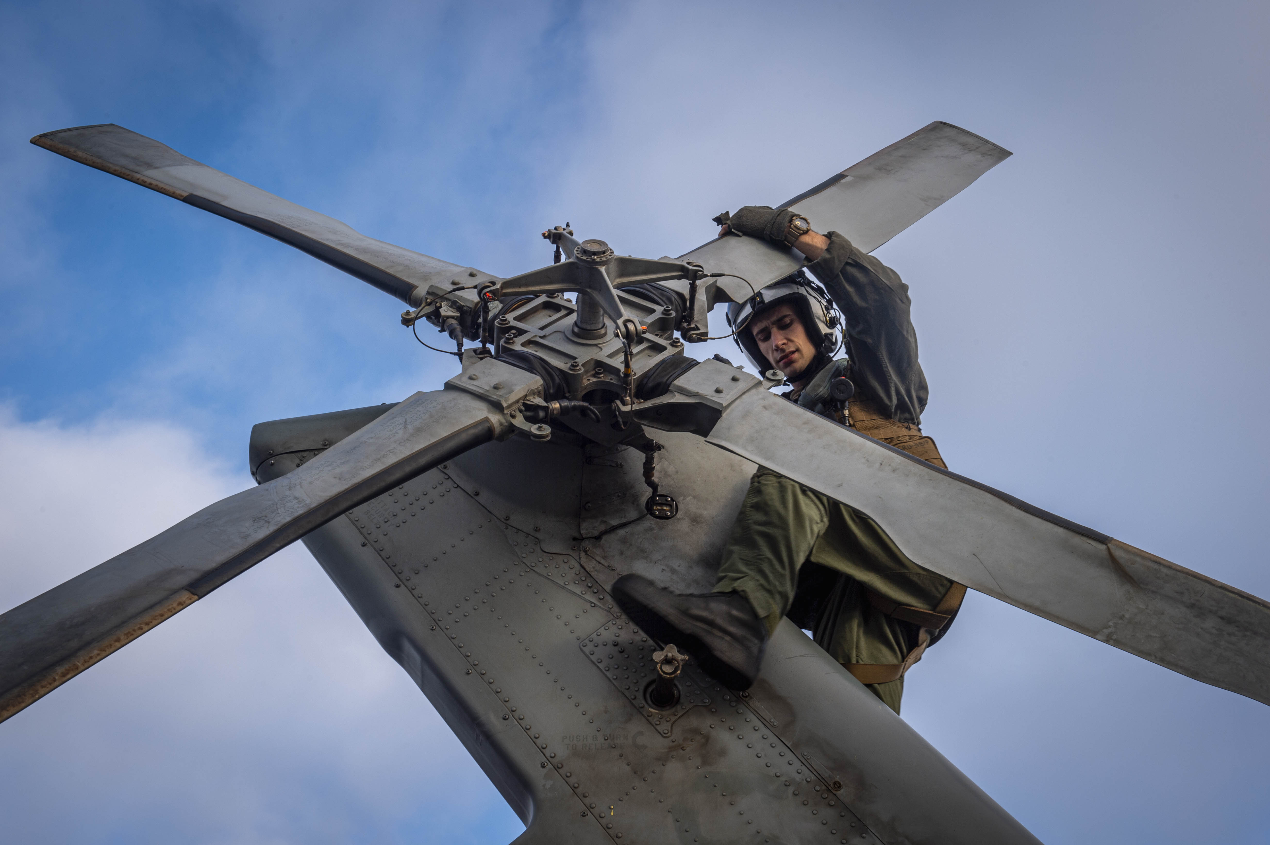 Naval Aircrewman (Helicopter) 3rd Class Michael Case conducts preflight checks on MH-60S Sea Hawk helicopter assigned to “Black Knights” of Helicopter Sea Combat Squadron 4 while underway operating with USS Carl Vinson in Pacific Ocean, August 13, 2024 (U.S. Navy/Kenneth Ostas)
